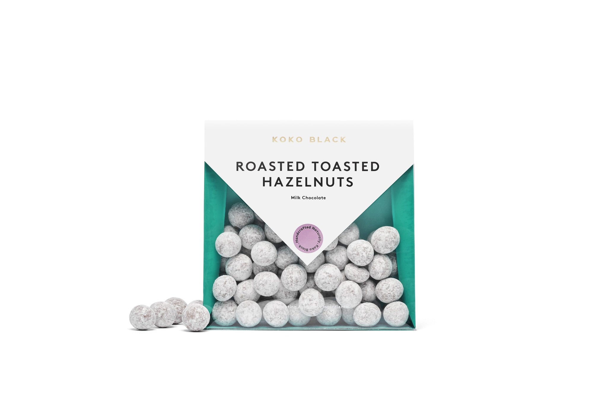 Dusted chocolate hazelnuts beside packaging